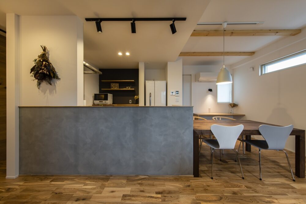 グレーの腰壁のキッチンとダイニング