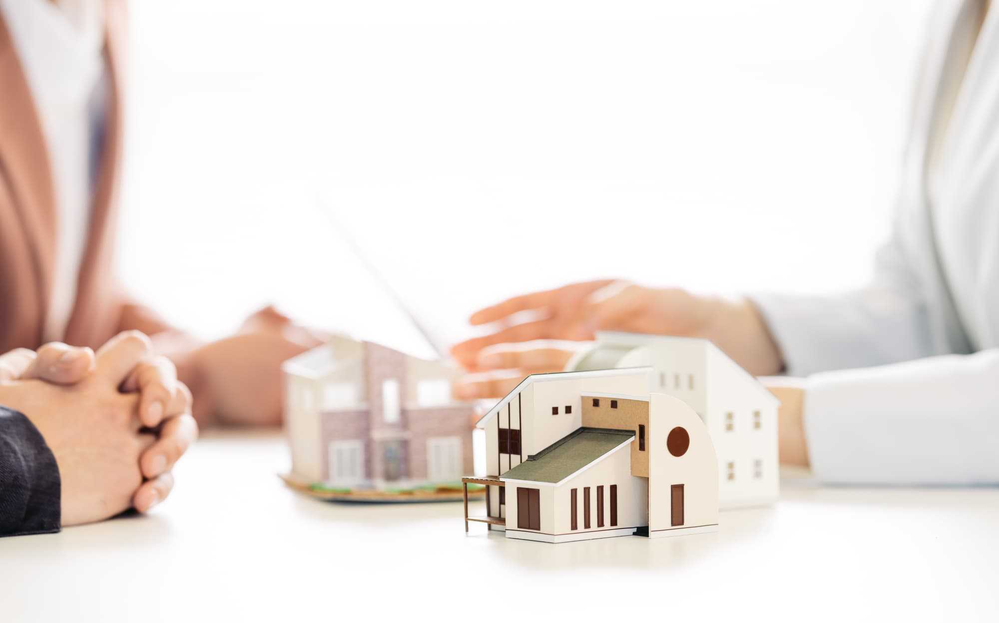 向かいあって相談している3人と住宅模型